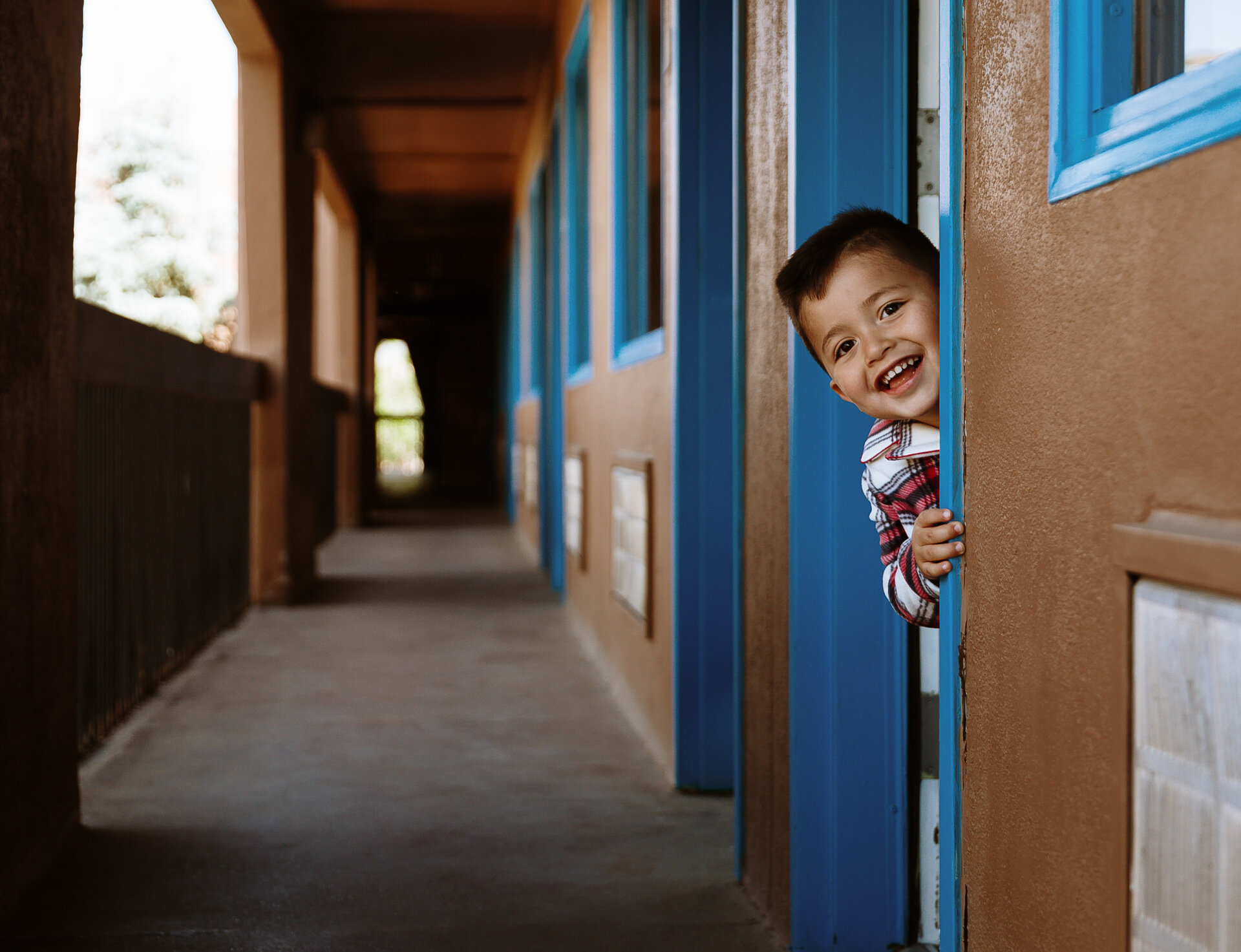 child peeking out of room door